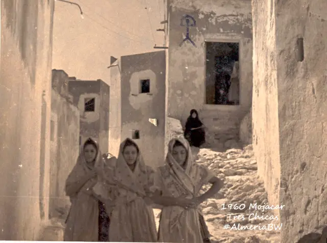 Tres jóvenes caminando por una calle de Mojácar hacia 1960